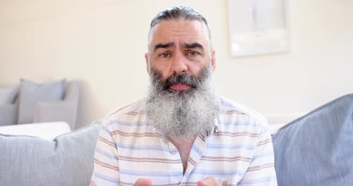 Man with Gray Beard Talking Indoors