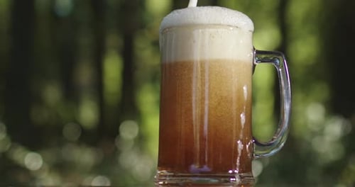 Beer Being Poured Into Glass Mug Outdoors