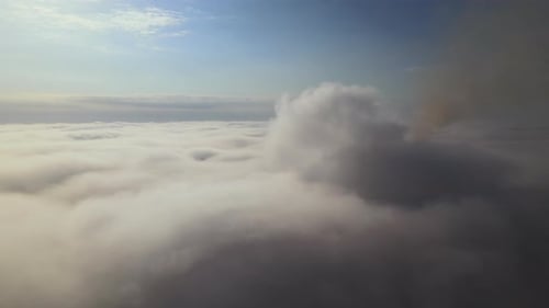 Aerial View From Airplane Window at High Altitude of Earth Covered with Puffy Cumulus Clouds Forming
