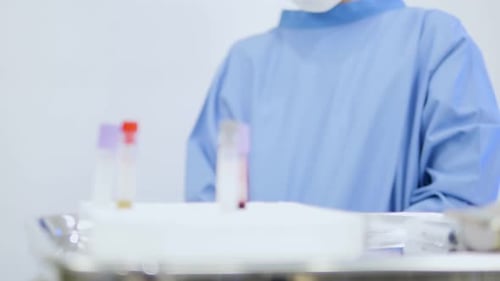 Close-up of an Asian female doctor writing a list of blood test results.