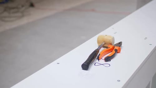 Hammer and Pliers on White Counter in Entertainment Center