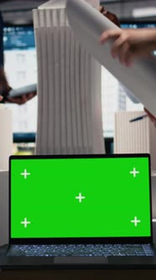 Vertical Video Real Estate Experts Analyzing Blueprints and Models Next to Green Screen