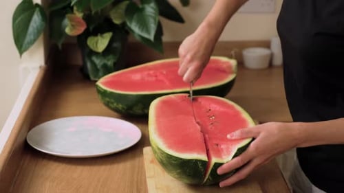 Cutting Ripe Watermelon Into Sections Splitting Bright Red Flesh with Knife Preparing Juicy Slices