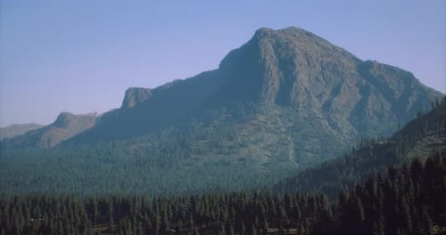 Majestic Mountain Landscape Surrounded By Lush Evergreen Forests in Daylight