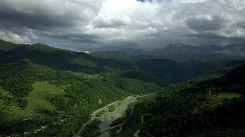 River Running Through a Lush Green Valley Surrounded By Mountains and a Lush Green Valley