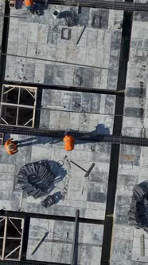 Vertical Video of Cranes Moving Large Steel Pieces Across Construction Site
