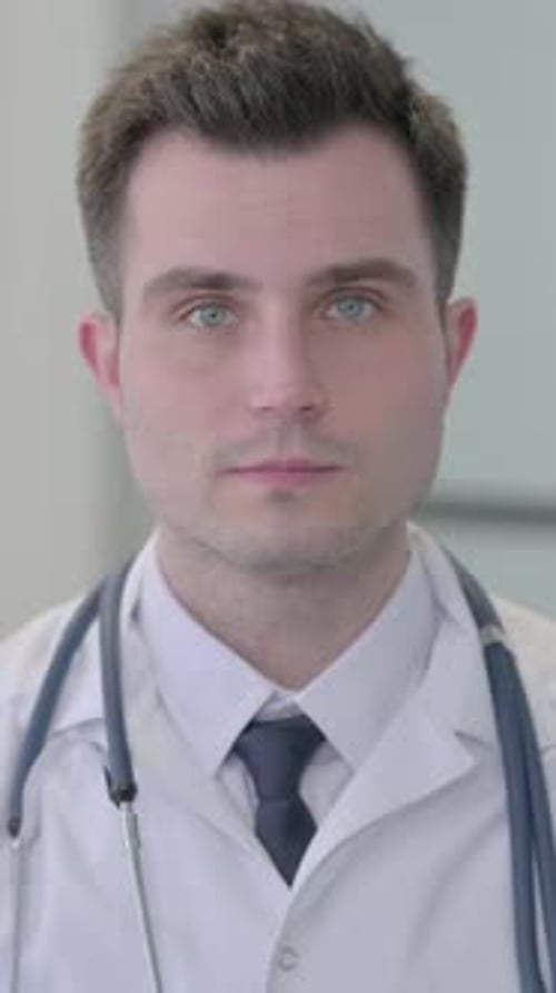 Portrait of Serious Male Young Doctor in Clinic, vertical video