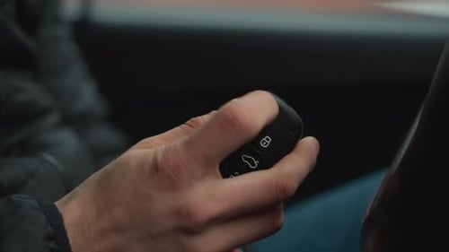 Nahaufnahme des Autofahrers, der den Autoschlüsselanhängerknopf drückt, wodurch der Schlüssel herausklappt