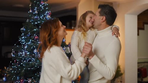 Loving Family Dancing near Christmas Tree at Home