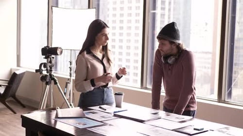 Colleagues Discussing Project in Office with Camera Setup