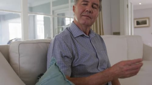 Mature Man Sitting on a Couch Thinking
