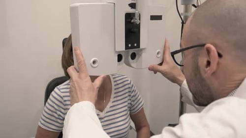 Patient Receiving Eye Exam From Optometrist In Exam Room