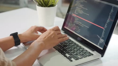 Mujer programadora escribiendo código HTML del programa sentada en el lugar de trabajo en la oficina