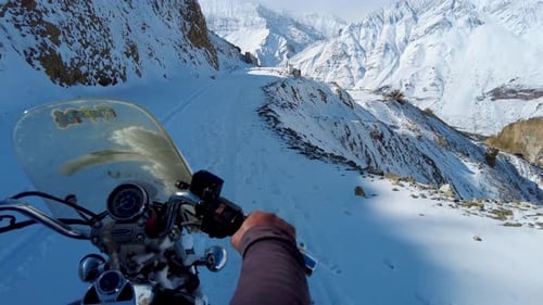 Riding a motorcycle on a snow-covered road in Spiti Valley, Himachal Pradesh