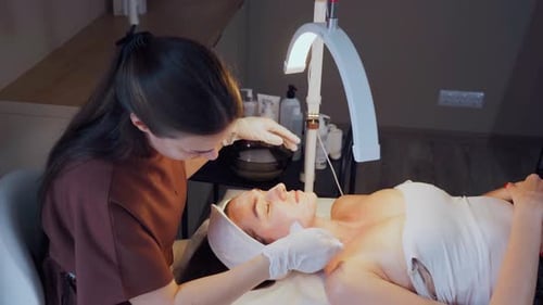 Woman Receiving Rejuvenating Facial at a Serene Spa