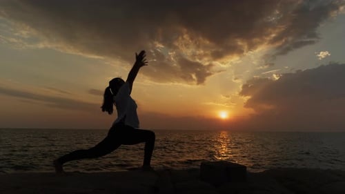 Femme pratiquant le yoga Crescent Lunge au coucher du soleil au bord de l'océan — Silhouette Balance Meditation