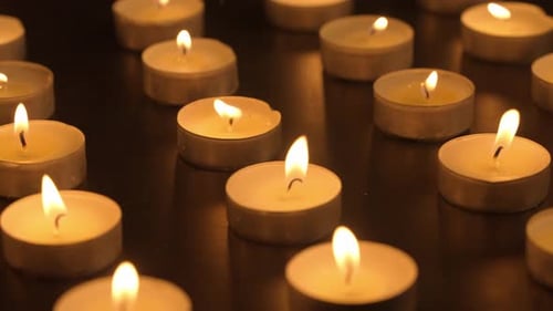 Rows of Burning Candles The Candles Burn Against a Black Background and the Flames Move When the