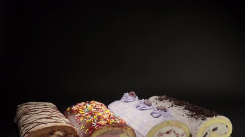 Assorted Swiss Rolls Close Up on Black Background