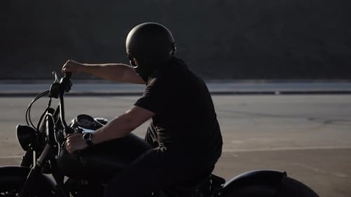 Man on a Black Motorcycle in Urban Setting