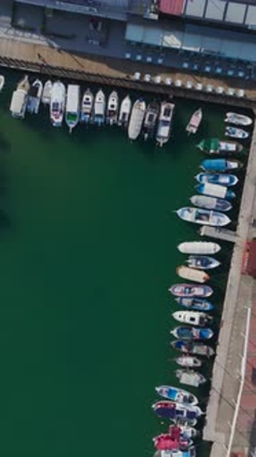 Vertical Video of a Picturesque Coastal Port With Boats and Luxury Yachts Captured From Above