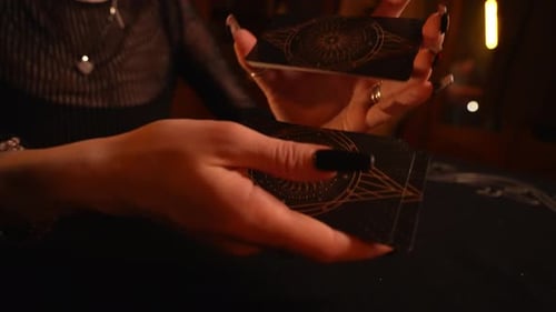 Woman Shuffles Tarot Cards in Dim Light