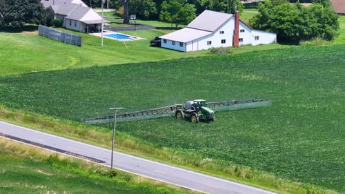Tractor Spraying Pesticide Fertilizer on Farm Field Agricultural Machinery at Work