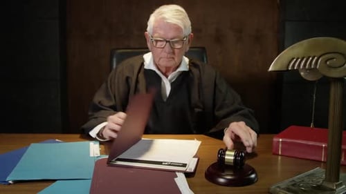 Judge bangs his gavel after reviewing court documents legal scene