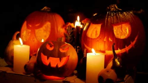 Geschnitzte Halloween-Kürbislichter im Inneren mit Flamme auf schwarzem Hintergrund. Feier von Halloween