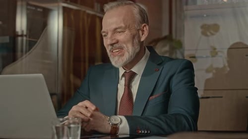 Man In Suit Works On Laptop In Office