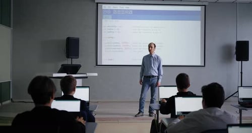 Männlicher Lehrer für Programmierung und Informatik spricht im Klassenzimmer mit Schülern Jungen