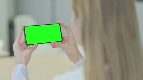Rear View of Woman Holding Smartphone with Chroma Key