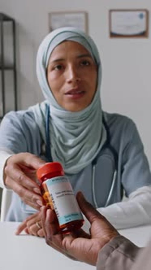 Smiling Gynaecologist Giving Vitamins to Pregnant Woman during Checkup