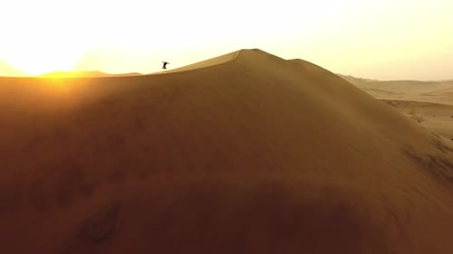 4k aerial drone footage of a solitary man walking along sand dunes in the Namibian Desert
