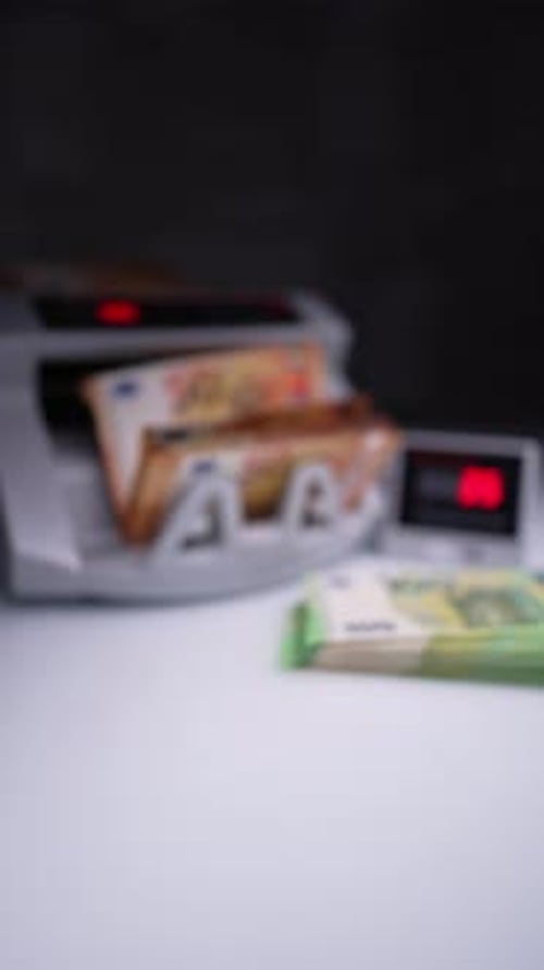 Orange banknotes are rotated and counted in money counting machine.
