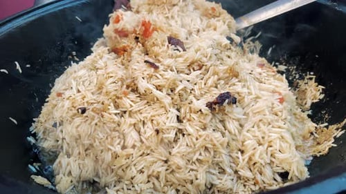 Seasoned Rice Dish Steaming and Stirred in Pot