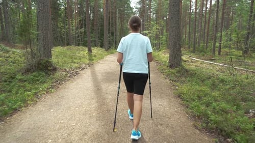 Active Woman Doing Nordic Walking in a Park