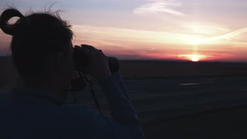 Female Silhouette With Binoculars at Sunset