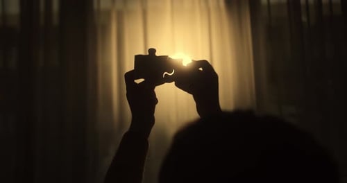 Mãos aproximadas de uma mulher conectando quebra-cabeças com a luz solar afetam o sucesso das soluções de negócios