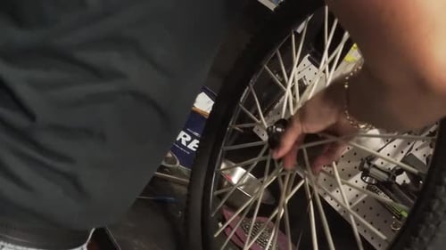 Mechanic cleaning the spokes of the rim of a mountain bike, still shot