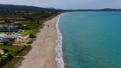 Aerial Drone Flies Along Beautiful Beach with Turquoise Sea, Lined with Luxury Hotels and Resorts