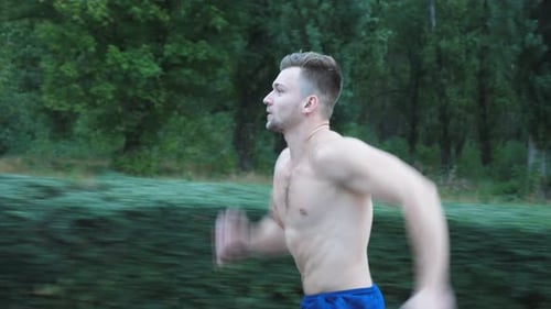 Athletic Handsome Man Sprinting Fast Along Trail Near Forest at Summer Day Young Muscular Sportsman