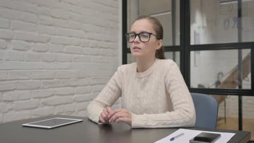 Woman Sitting at Desk Taking Deep Breaths