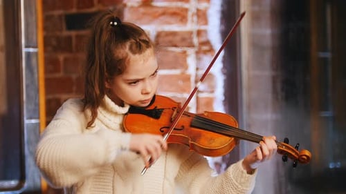 Focused Girl Plays Violin in Home Setting