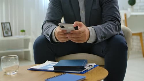 Businessman Using Smartphone in Modern Office Setting