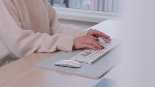 Woman Typing on Computer Keyboard at Desk