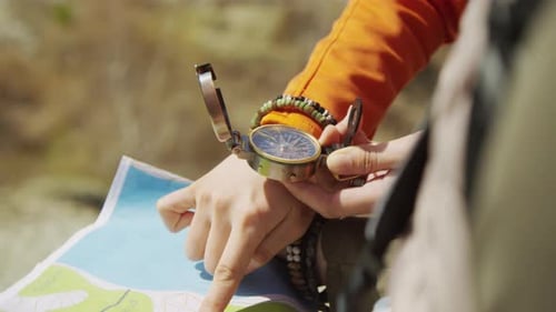 Hands Use Compass and Map for Outdoor Navigation