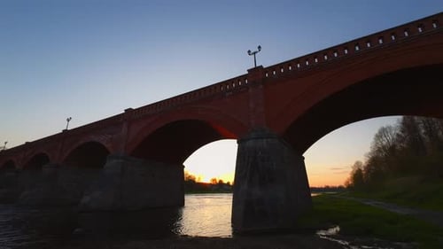 Arch Bridge Made of Composite Material Crossing the River at Sunset
