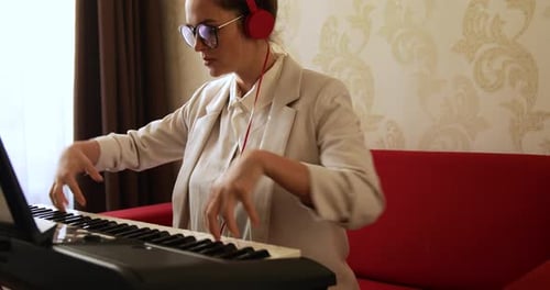 Woman Plays Digital Piano with Red Headphones