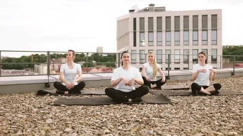 Young Women Meditating on a Rooftop