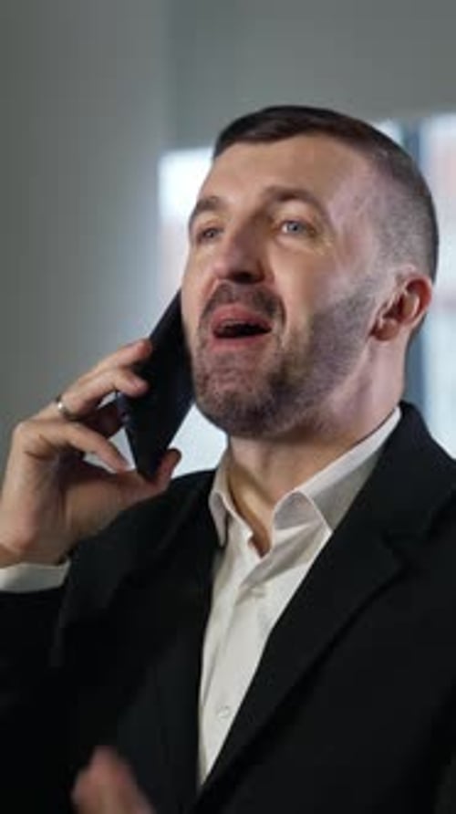 Man in Suit Talking on Phone Indoors